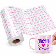 A roll of white transfer paper with a pink grid pattern is shown next to a pink ceramic mug printed with a purple 'MOM' design and a pink heart. A hand is holding the mug to demonstrate the transfer sheet's grid overlay.