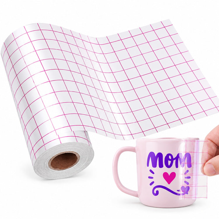 A roll of white transfer paper with a pink grid pattern is shown next to a pink ceramic mug printed with a purple 'MOM' design and a pink heart. A hand is holding the mug to demonstrate the transfer sheet's grid overlay.