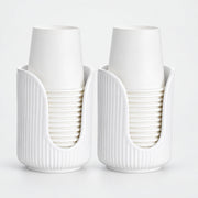 Two white ribbed cup holders, each holding a stack of white paper cups, photographed on a clean white background.