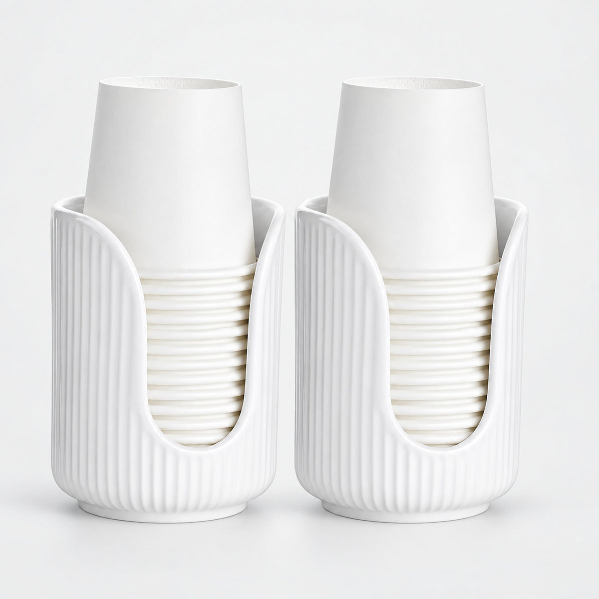 Two white ribbed cup holders, each holding a stack of white paper cups, photographed on a clean white background.