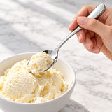 Silver teaspoon used to scoop ice cream; dessert and bowl not included.