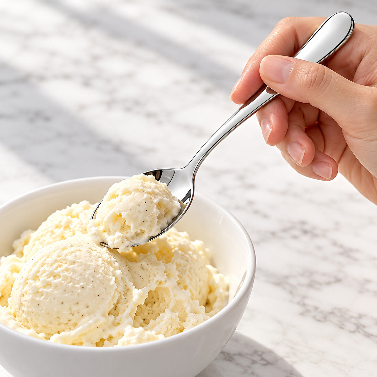 Silver teaspoon used to scoop ice cream; dessert and bowl not included.