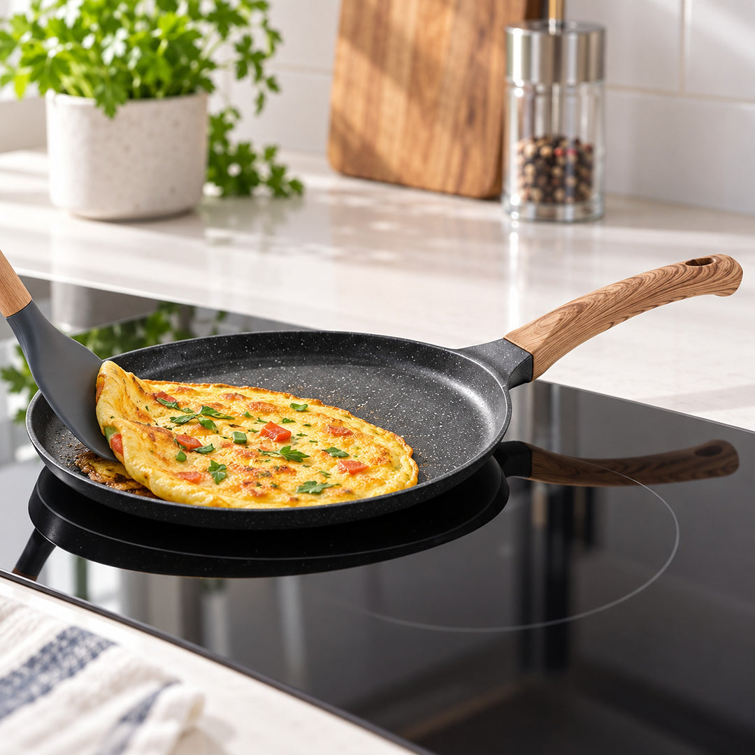 Lifting an omelet from the shallow Maifan-coated pan on an induction hob.