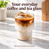 Clear ribbed stepped-base glass serving iced latte; one cup, accessories not included.