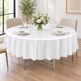 One white disposable round table cover set for a celebration meal.