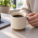 White ribbed ceramic mug used for an office coffee break.