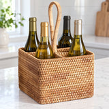 Square handled wicker basket holding four bottles on a counter; bottles not included.