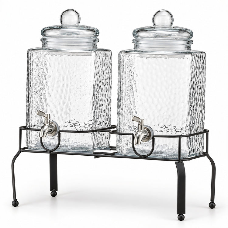 Two clear glass canisters with a hammered texture, each with a lid and a metal spout, displayed on a black metal stand against a white background.