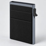 Gray metal card wallet showing its textured front pocket and side lever.