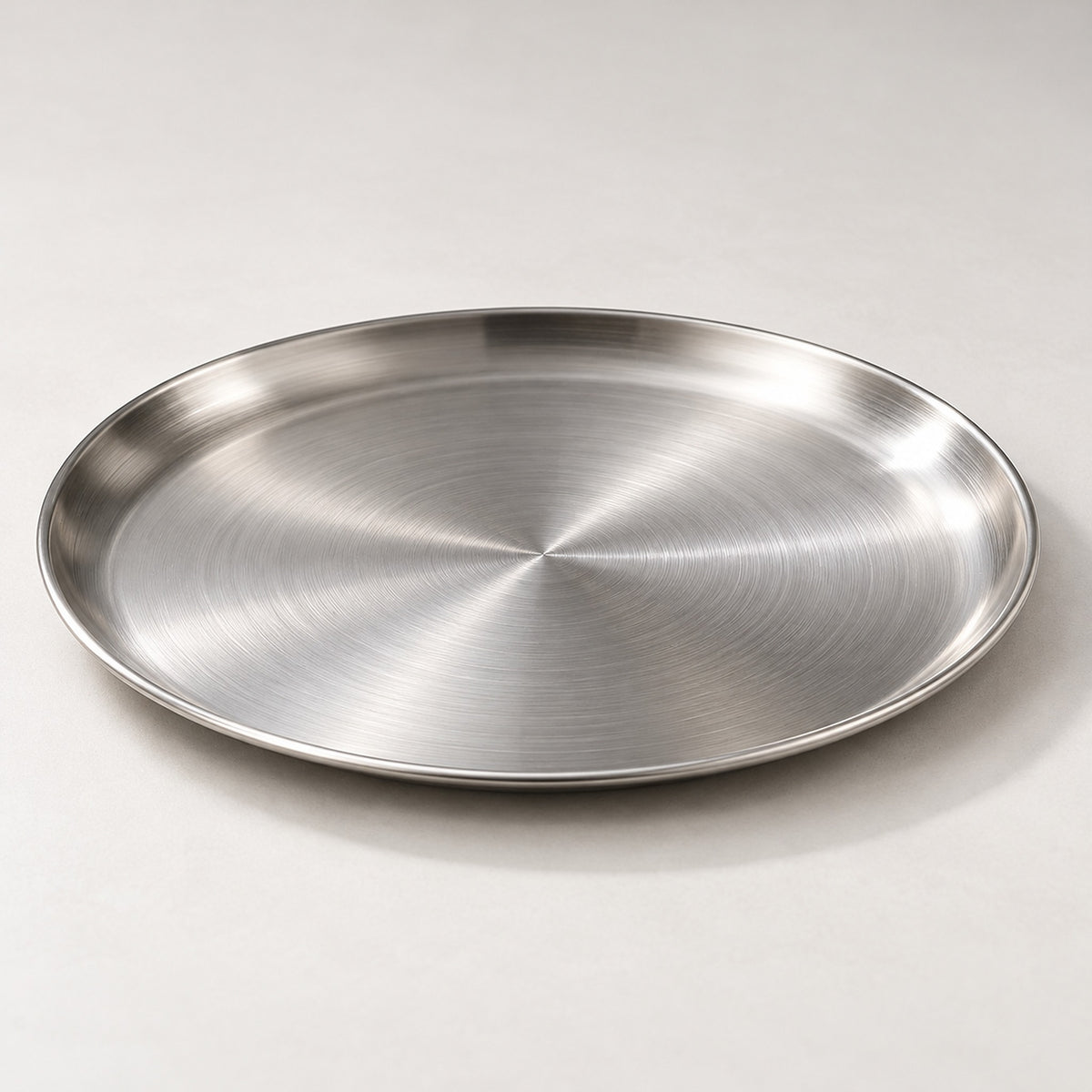 Close view of the brushed silver stainless steel surface and low rolled rim.