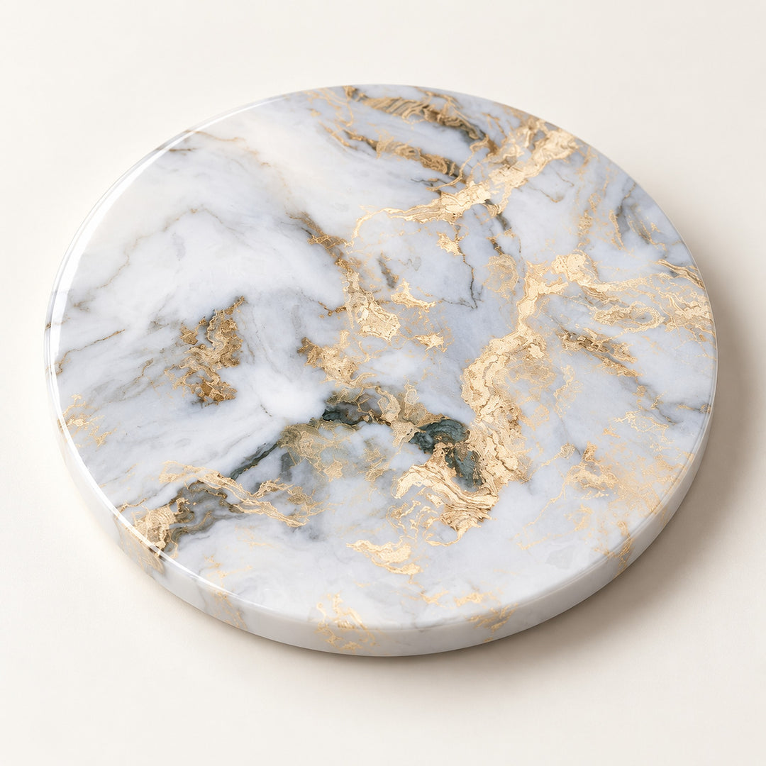 A round marble-patterned coaster with white, gray, and gold veining, photographed from a top-down angle on a light cream background.