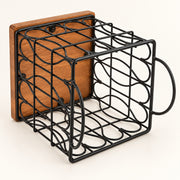 A black metal wire wine rack designed in the shape of a mug, featuring a wooden back panel and a side handle, shown on a clean off-white background.