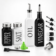 A kitchen glassware and bottle set arranged on a white background, including a black pepper shaker, a white salt shaker, a tall white oil bottle, a tall black vinegar bottle, several pour spouts, a green funnel, a metal funnel, and a black cleaning brush.