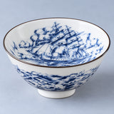Close view of the Sailing Ship motif inside a blue-and-white porcelain tea cup.