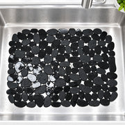 Black pebble-look wall tiles arranged in a rectangular pattern inside a stainless steel kitchen sink.