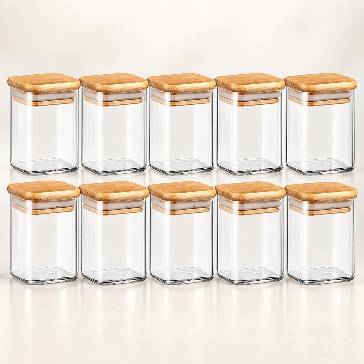Ten clear glass spice jars with light brown bamboo lids, arranged in two rows of five on a clean white background.