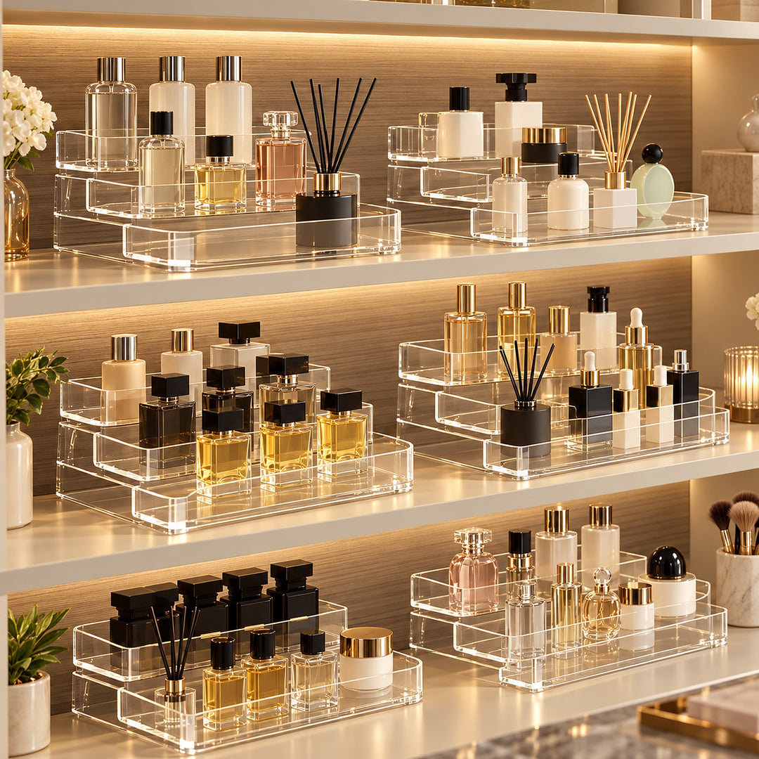 Clear acrylic cosmetic organizer trays arranged on warm white shelves with built-in LED lighting, holding assorted perfume bottles, diffusers, and cosmetic containers.