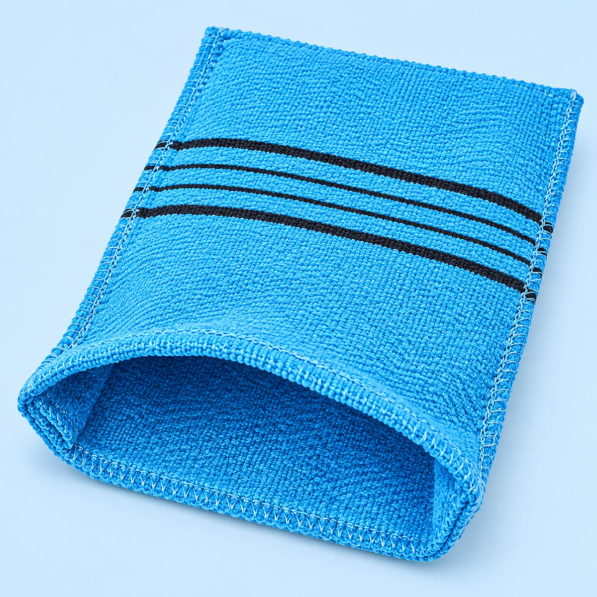 Blue exfoliating mitt with its open hand pocket and reinforced stitched edge visible.