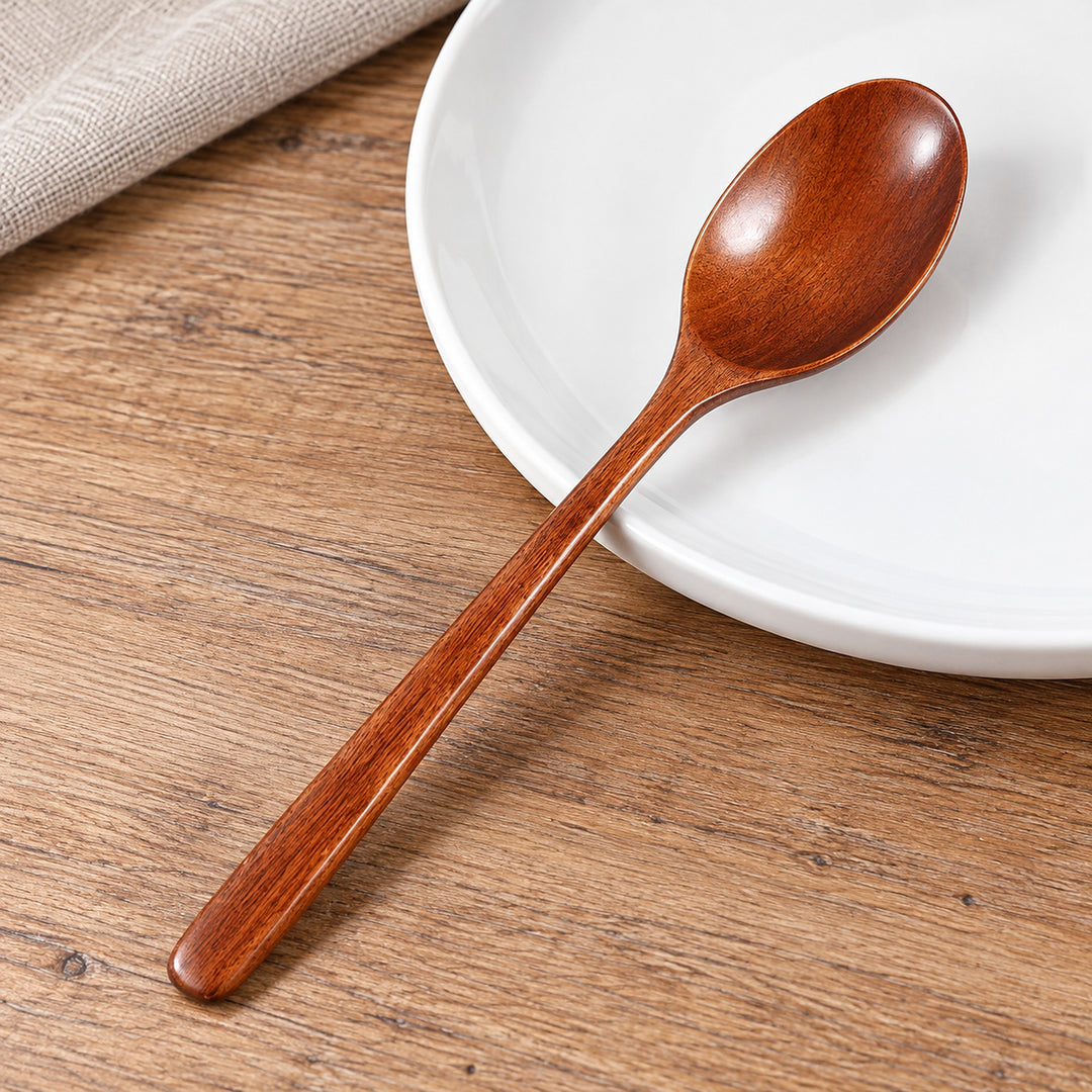 Wood spoon showing its shallow oval bowl, smooth neck and slim handle.