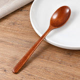 Wood spoon showing its shallow oval bowl, smooth neck and slim handle.