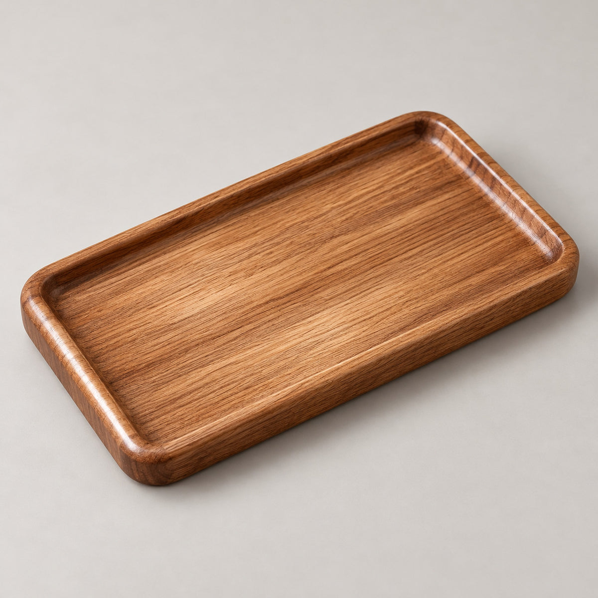 Small rectangular wood tray showing its recessed bed and rounded raised rim.