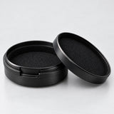 Open round aluminum case showing its soft black interior lining.