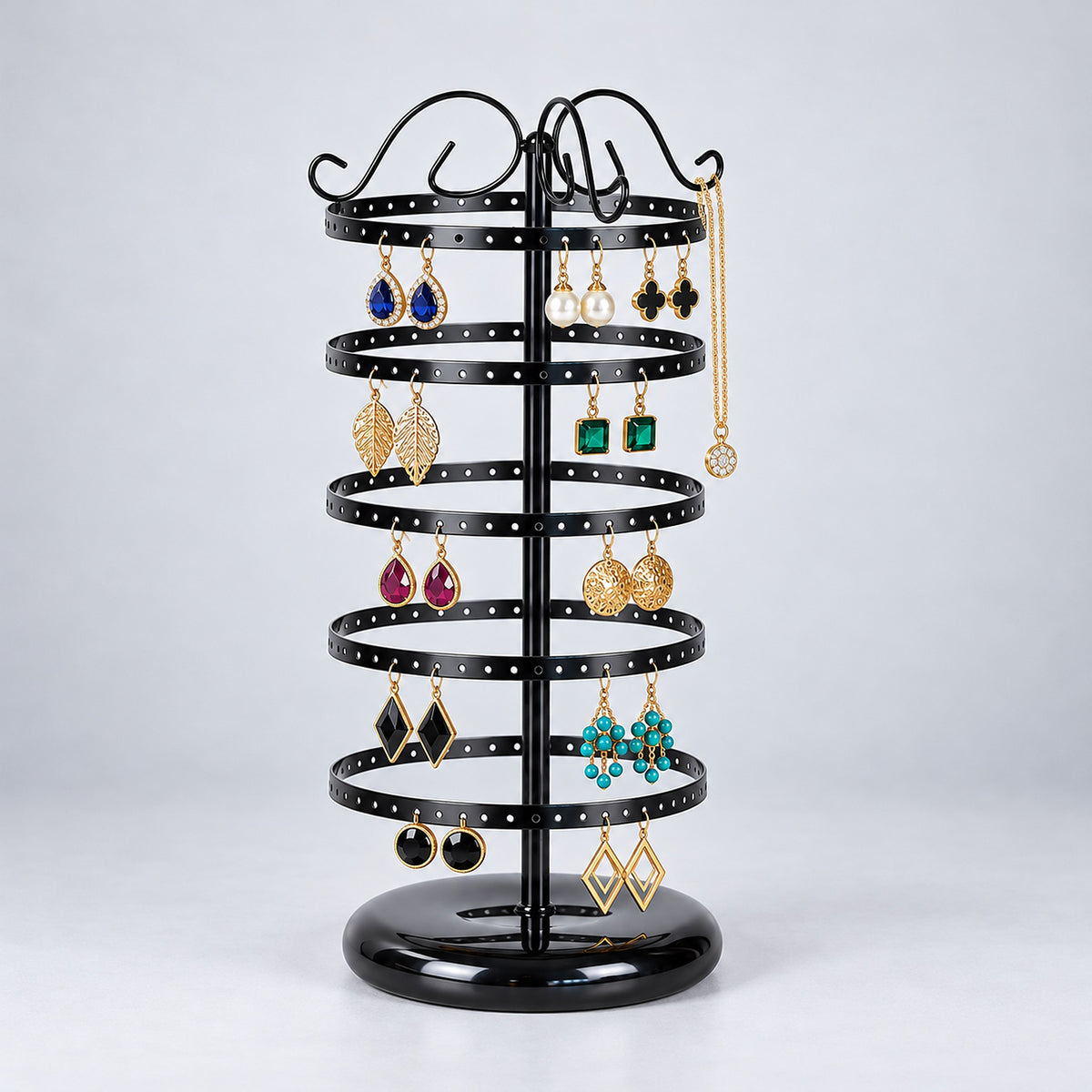 Five-tier black stand with earrings and a necklace on an upper hook.