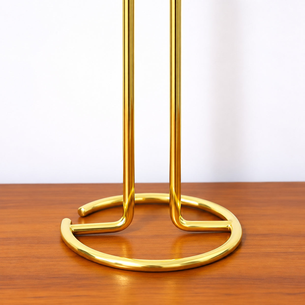 Open circular wire base and bent support rods of the gold stand.