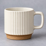 Rounded rectangular handle and glazed rim of the ceramic mug.