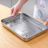 Hand lifting the removable rack to reveal raised feet and the tray below.