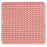 Water droplets on pink silicone mat wavy ridges.