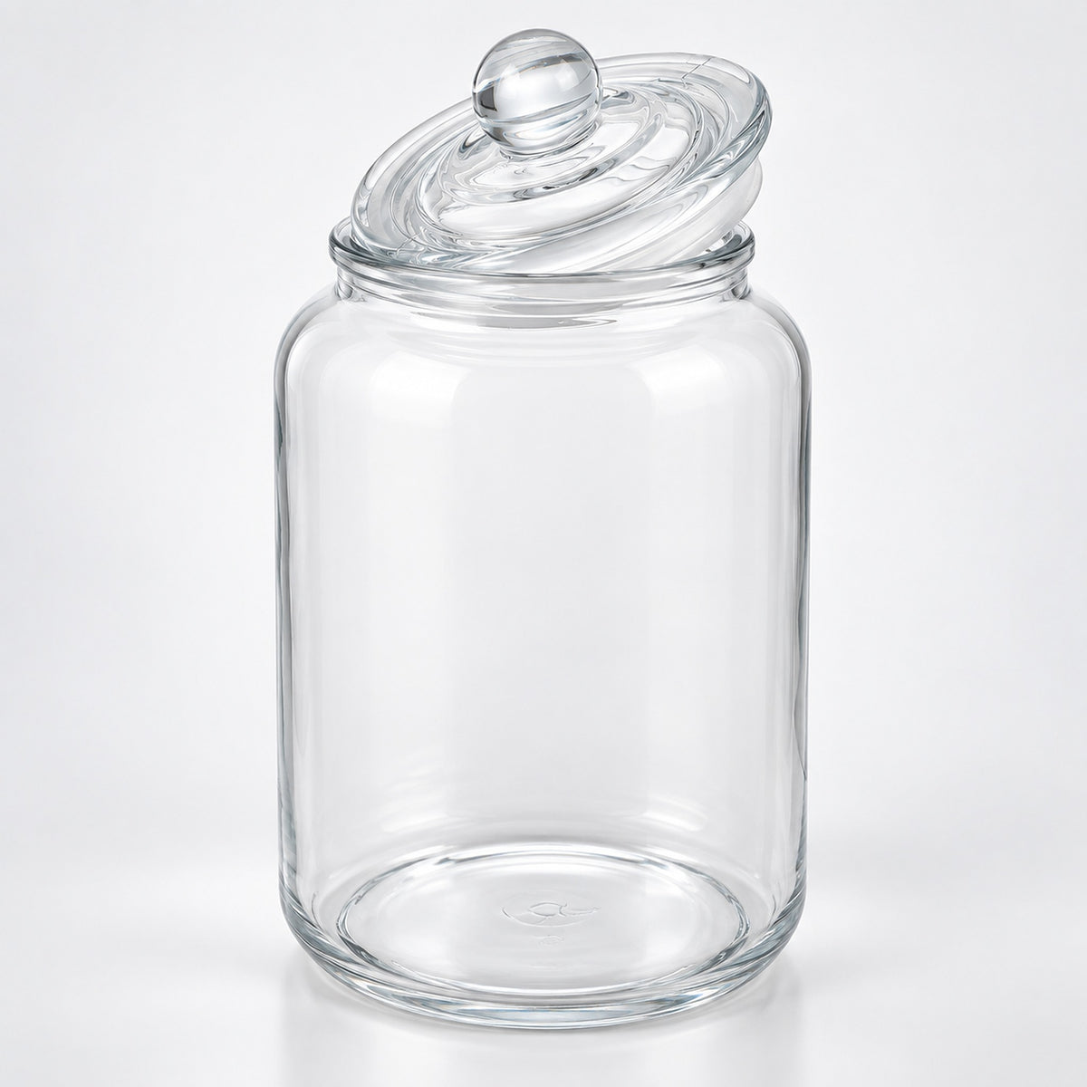 A clear glass jar with a matching glass lid featuring a round knob, photographed on a clean white background.