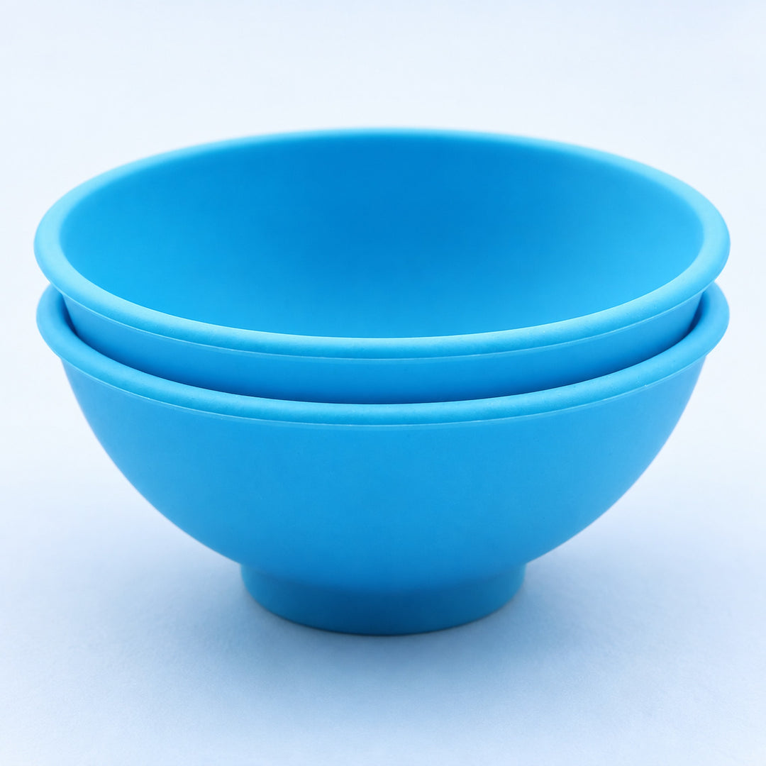 Two blue silicone mini bowls nested for compact storage.