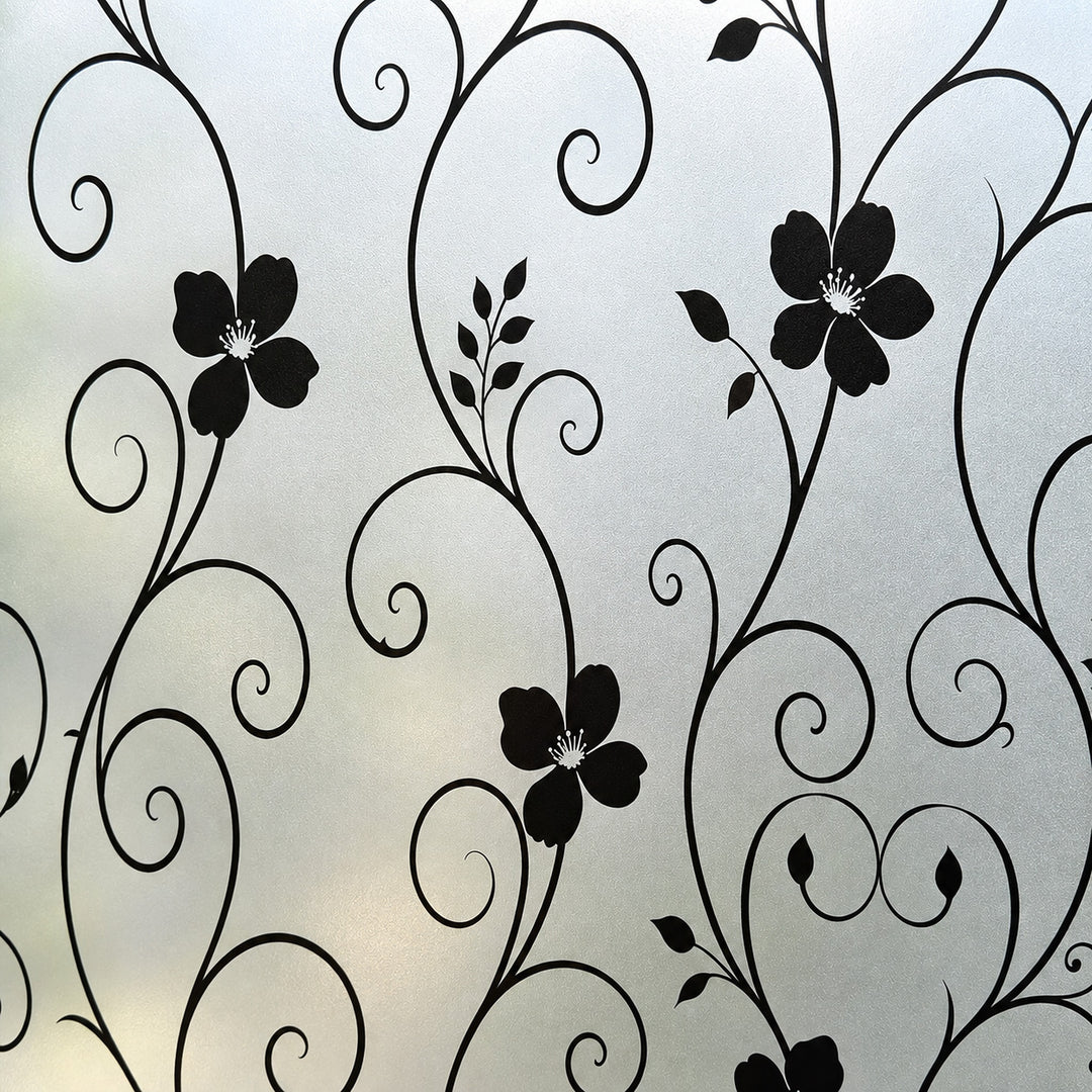Black floral scroll pattern on a frosted light gray glass window film or decal.