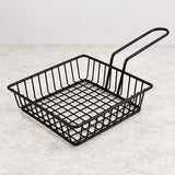One empty shallow square black iron wire serving basket with handle.