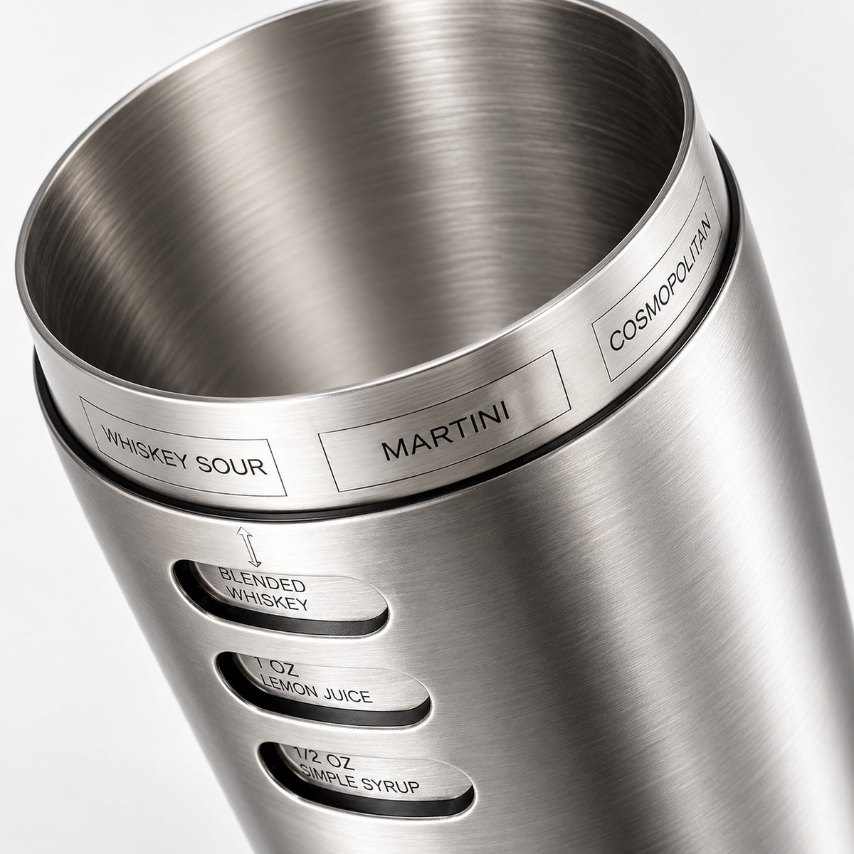 Close-up of a brushed stainless steel cocktail muddler with engraved flavor and ratio labels including Whiskey Sour, Martini, Cosmopolitan, Blended Whiskey, 1 oz Lemon Juice, and 1/2 oz Campile Syrup.