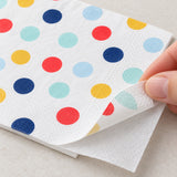 Two thin tissue plies at the corner of a printed paper napkin.