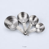 Four empty measuring cups and their joining ring; cups-only set.