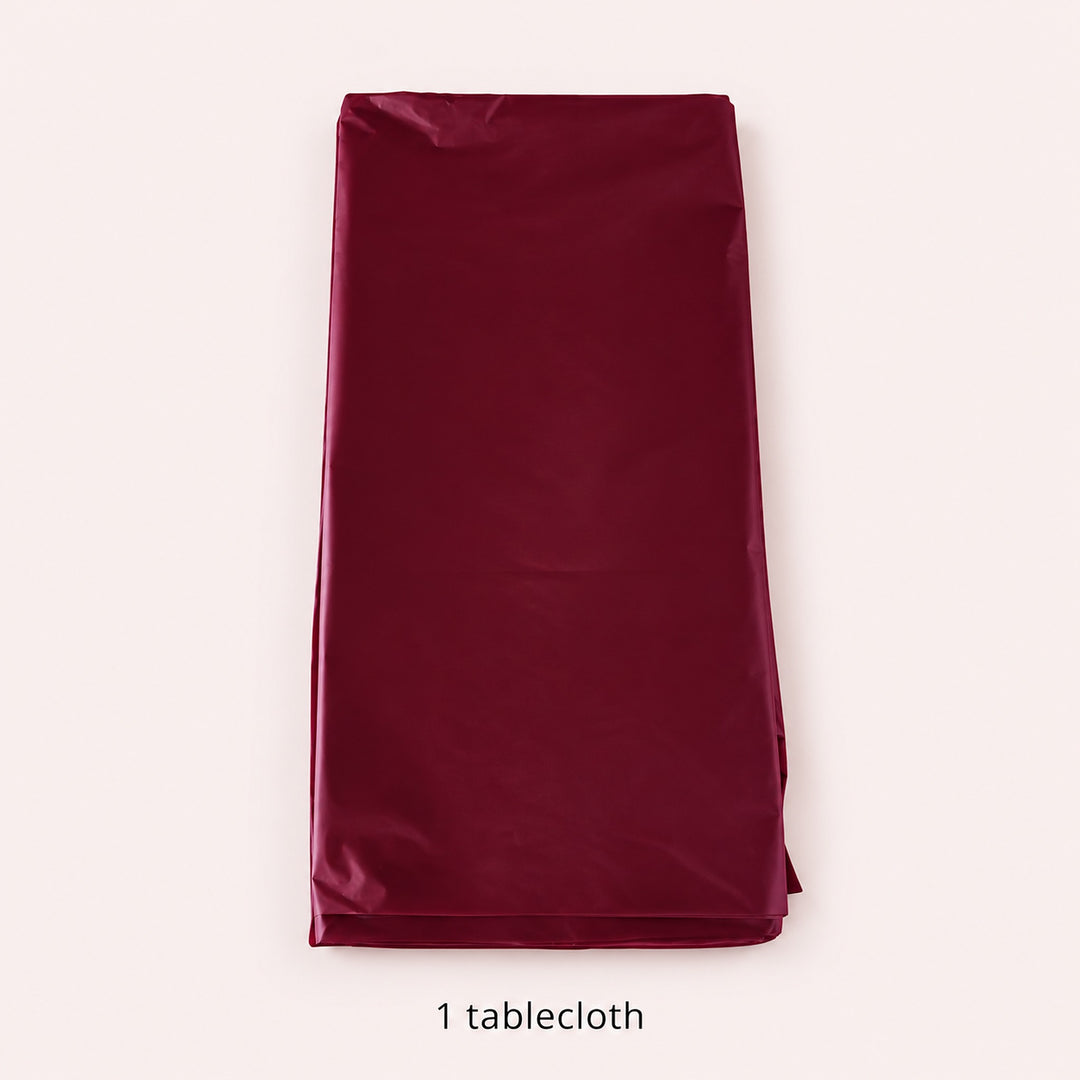 One folded wine-red disposable round tablecloth.