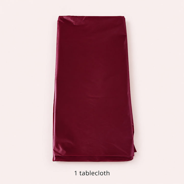 One folded wine-red disposable round tablecloth.