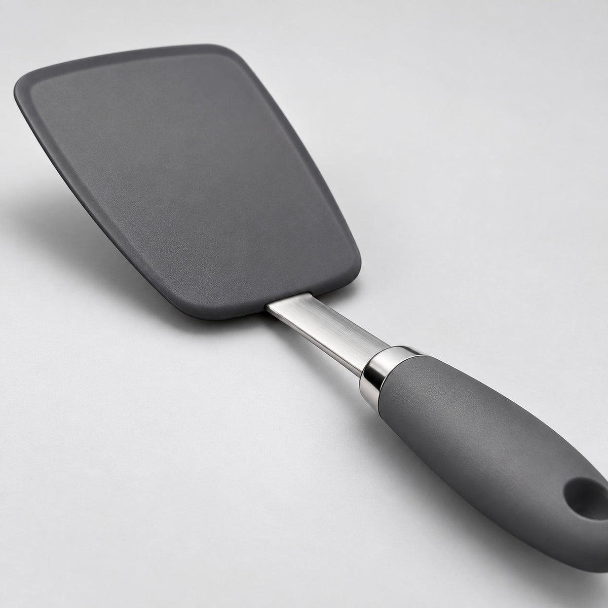 Close view of the silicone head, flat steel shaft, and metal collar.