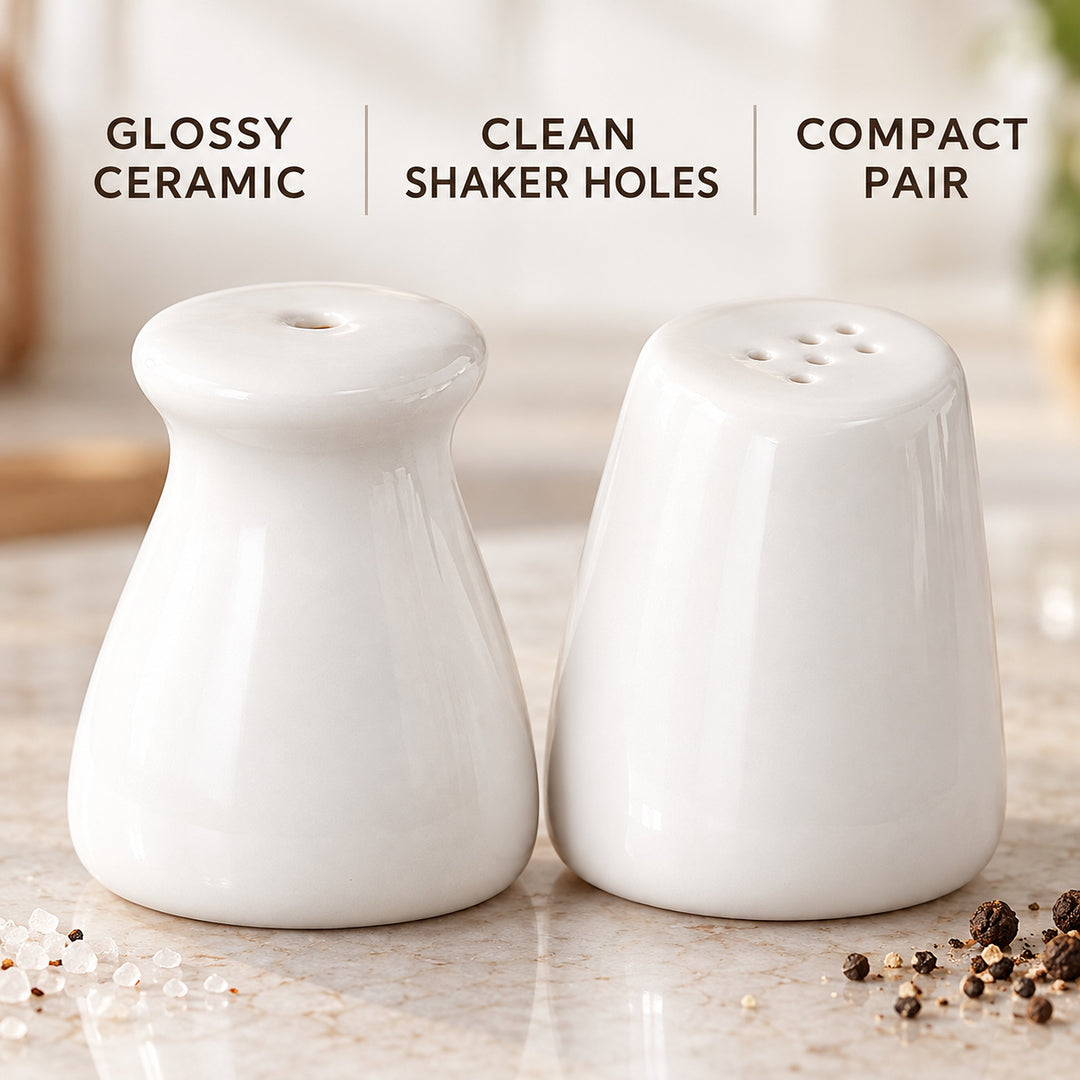 Two glossy white ceramic salt and pepper shakers on a marble countertop with text overlays reading 'GLISSY CERAMIC', 'CLEAN SHAKER HOLES', and 'COMPACT PAIR'.