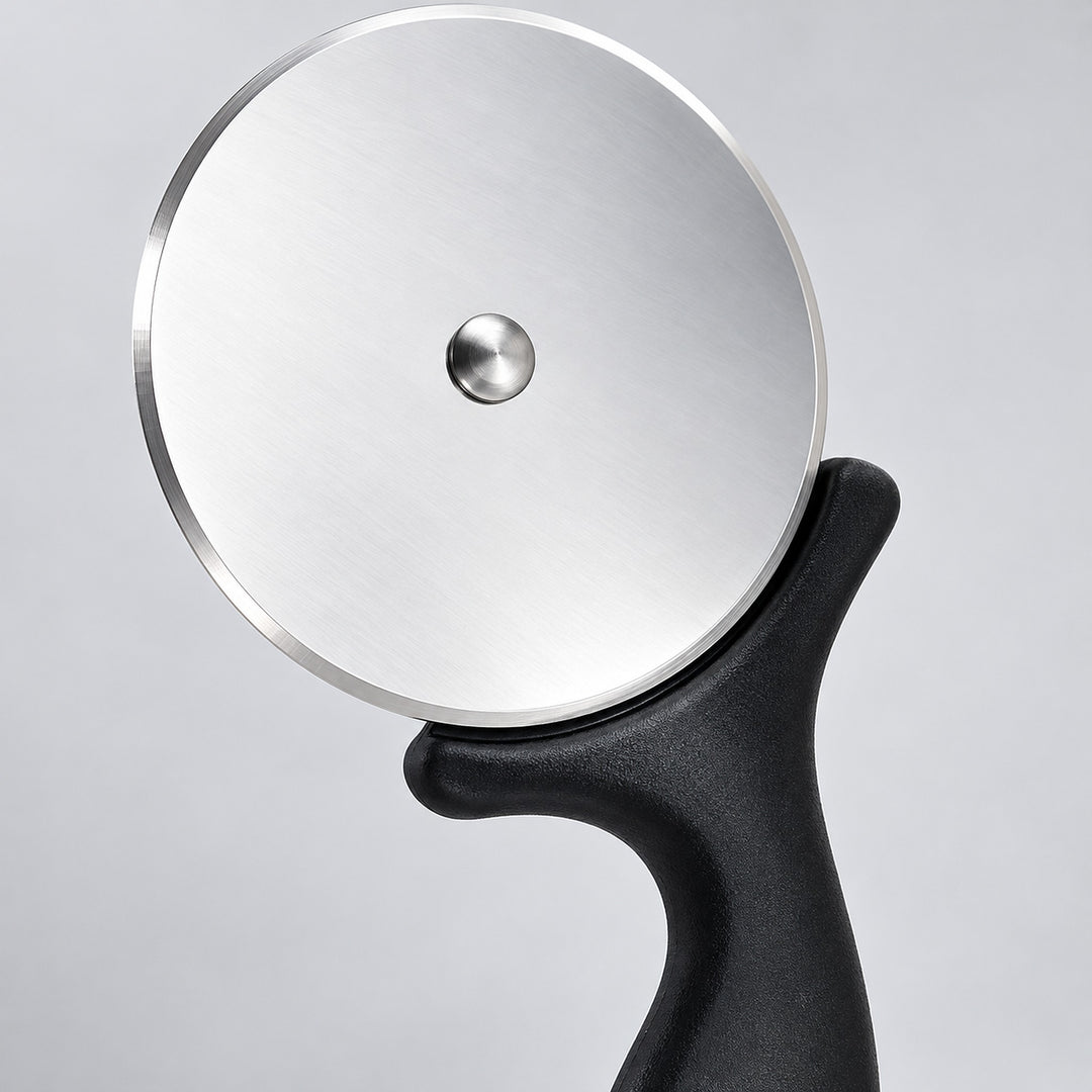 Close-up of the steel pizza wheel, center rivet and black handle guard.