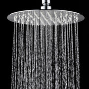 A round chrome rain shower head with water cascading down against a solid black background.