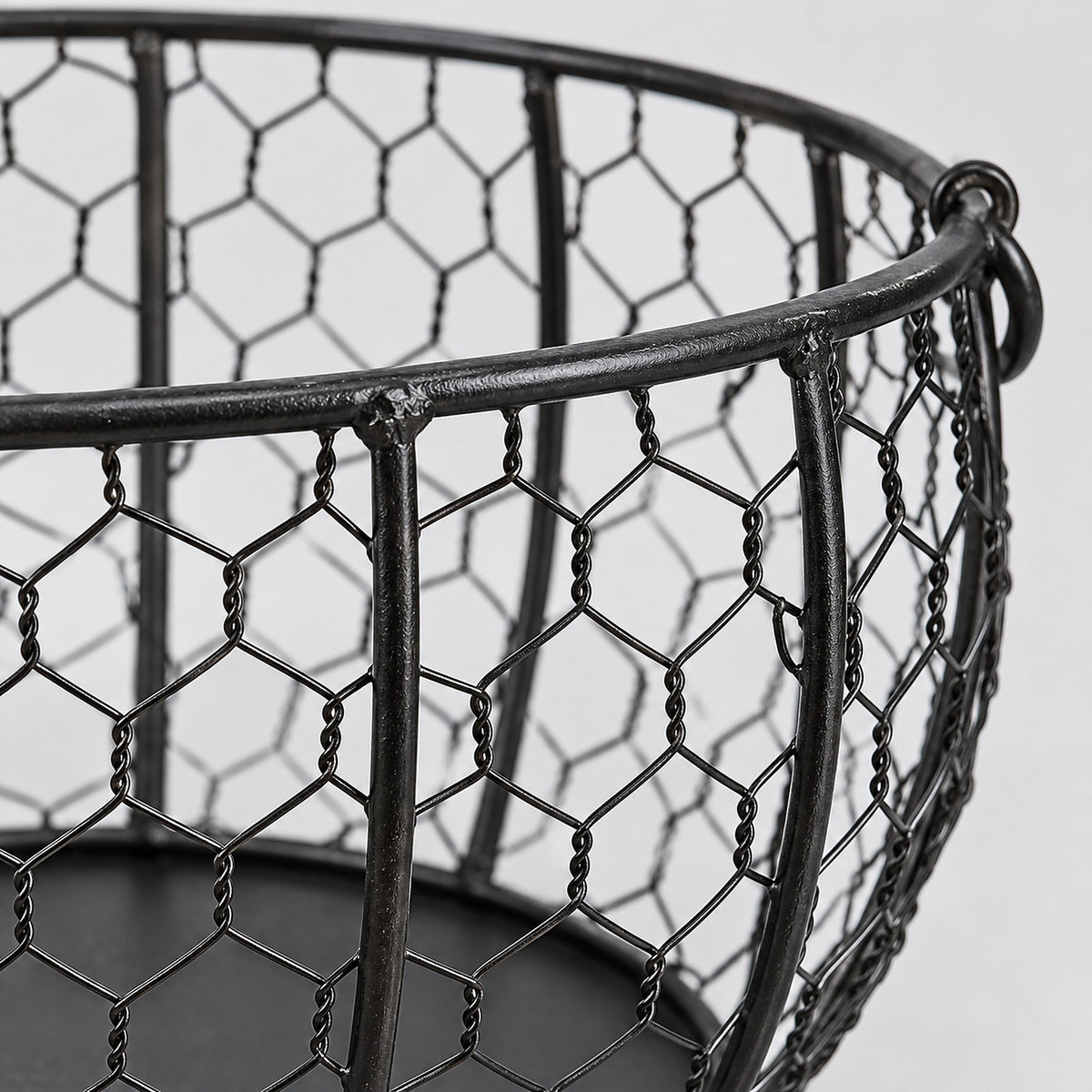 Close-up of the egg basket's black hexagonal wire mesh and reinforced rim.