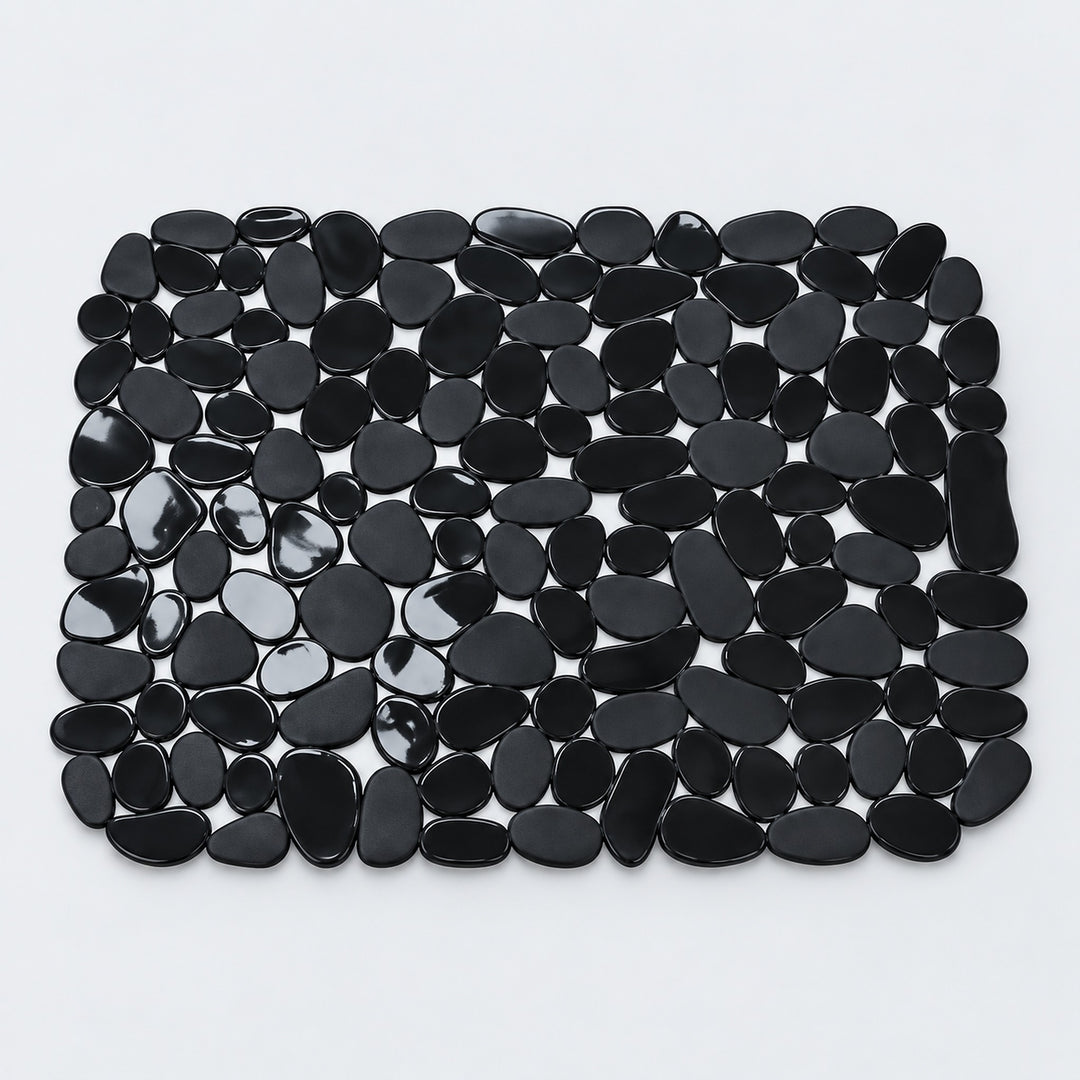 A rectangular black pebble mat made of smooth, glossy black stones arranged in a grid pattern on a light gray background.
