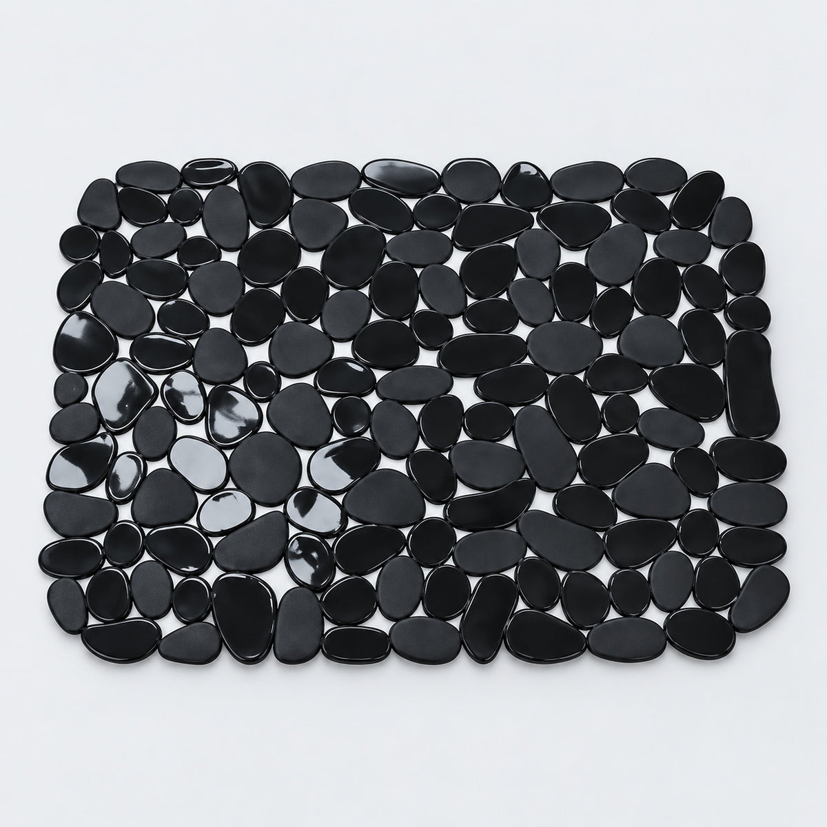 A rectangular black pebble mat made of smooth, glossy black stones arranged in a grid pattern on a light gray background.