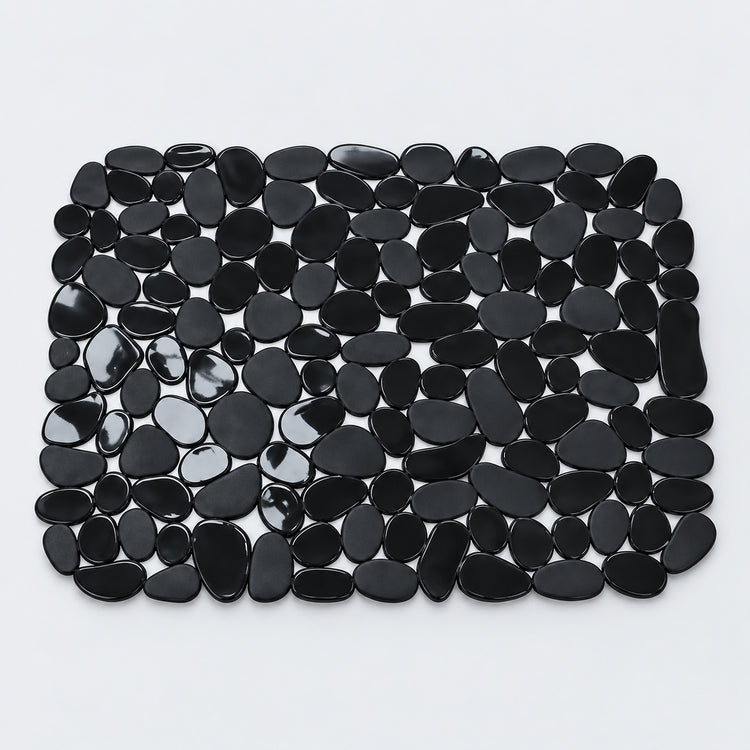 A rectangular black pebble mat made of smooth, glossy black stones arranged in a grid pattern on a light gray background.