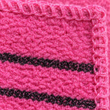 Close-up of pink exfoliating fabric texture, black stripes and the bound seam.