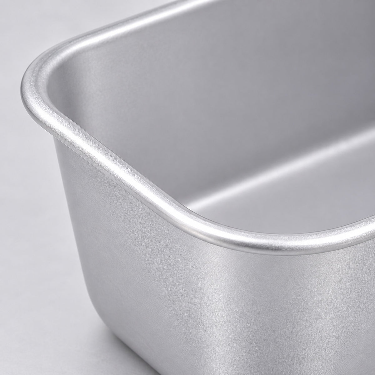 Close-up of the satin aluminum finish and rolled rim of the loaf pan.